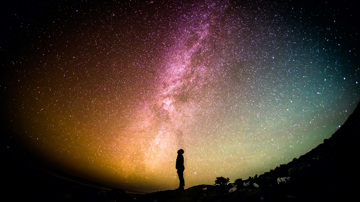 Man looking at milky way in starry sky