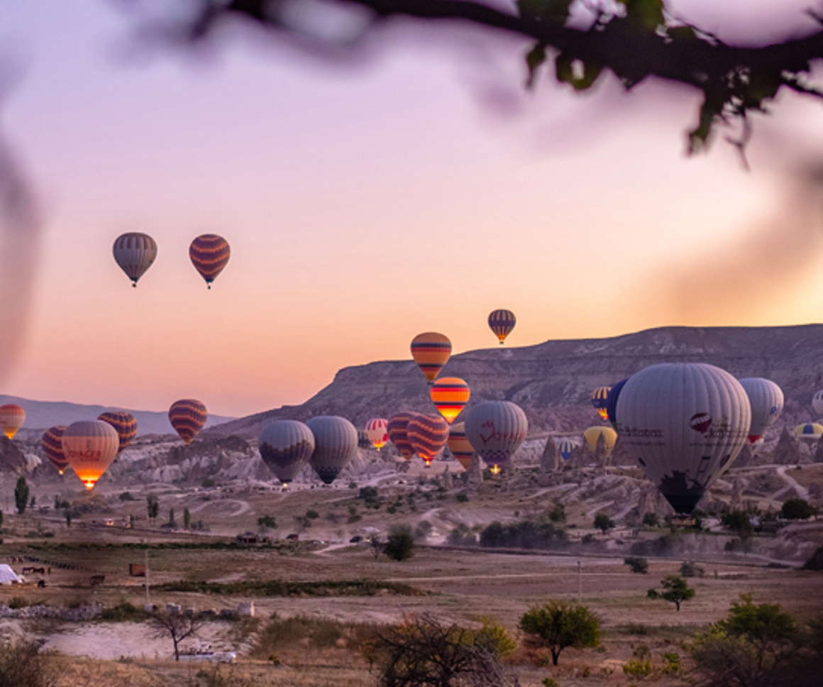 Hot air balloons flying over rocky landscape