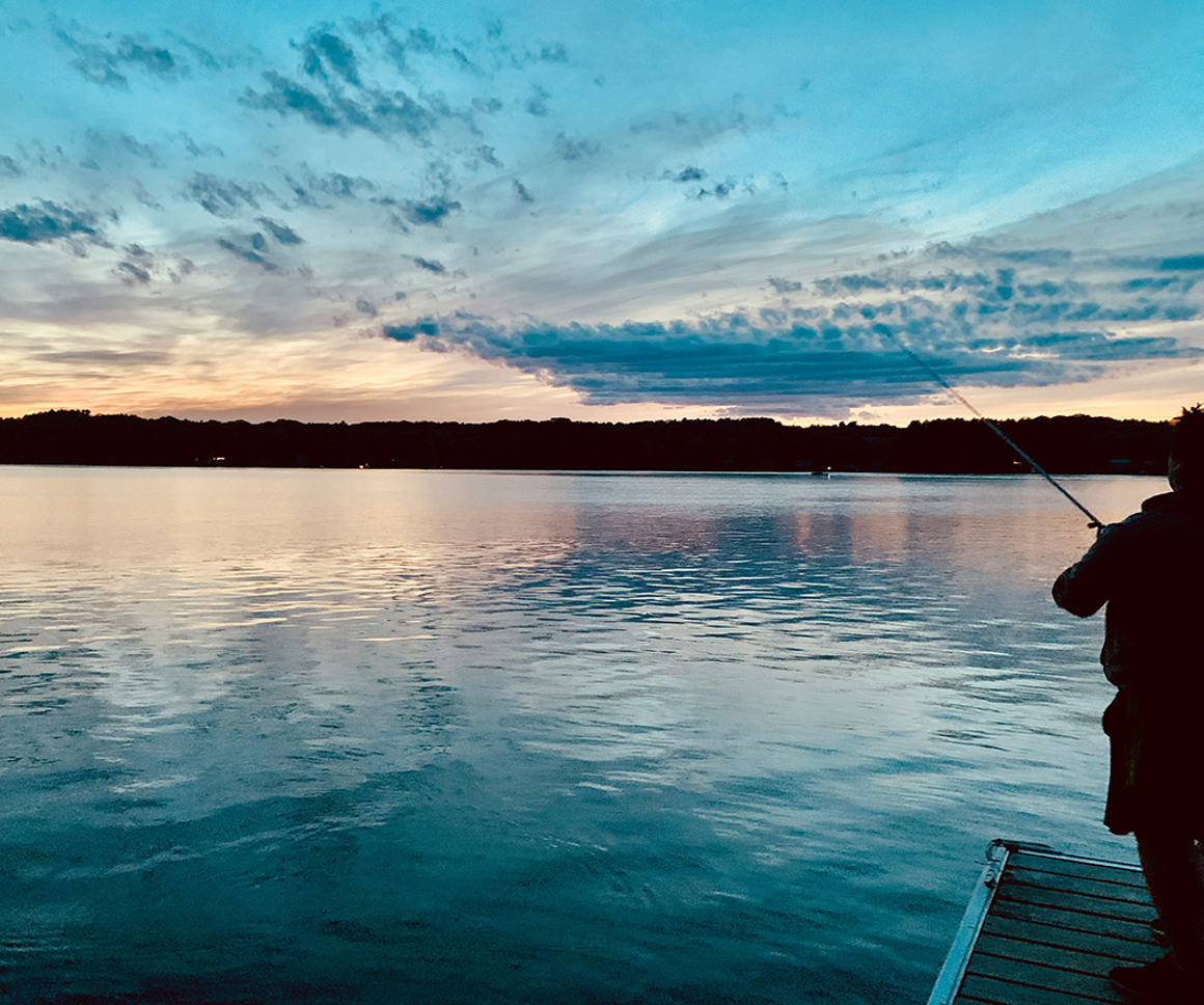 Fisherman on a pier at sunset