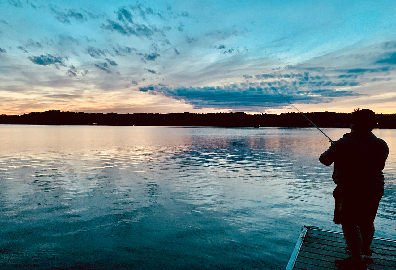 Fisherman on a pier at sunset