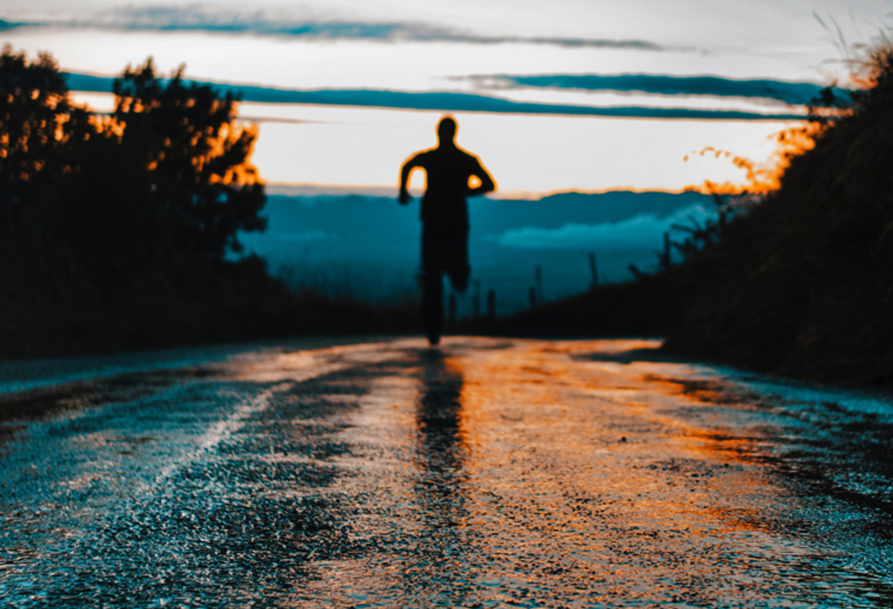 Man running down a road at night