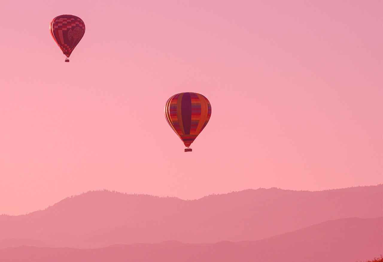 Hot air balloons against pink sky