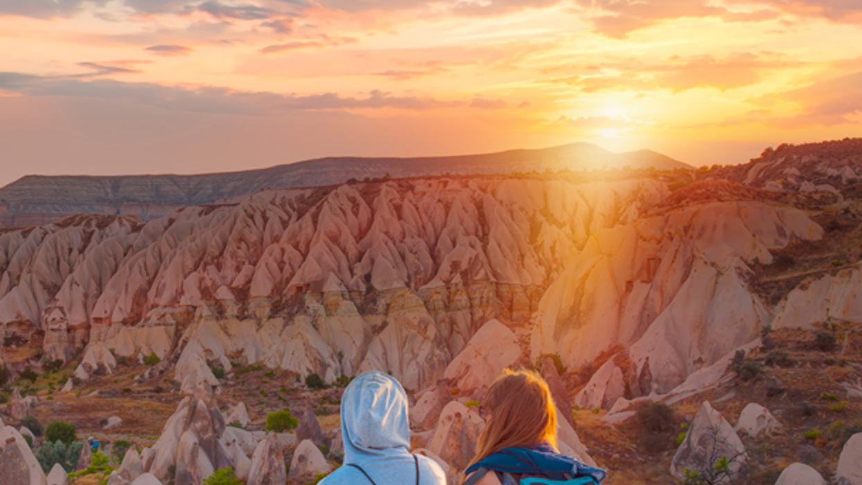 Two people sat looking over a rocky valley