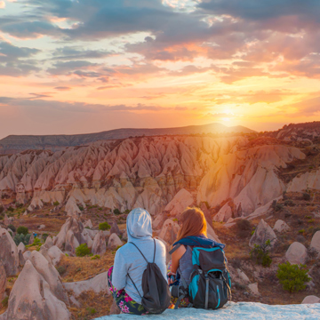Two people sat looking over a rocky valley