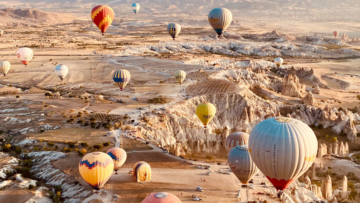 Hot air balloons flying over desert