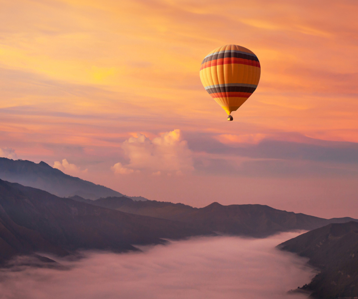 Hot air balloon over misty valley