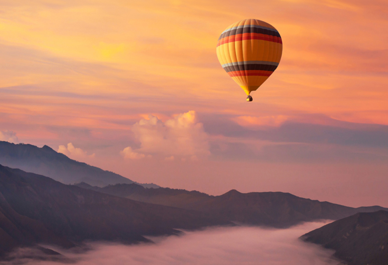 Hot air balloon over misty valley