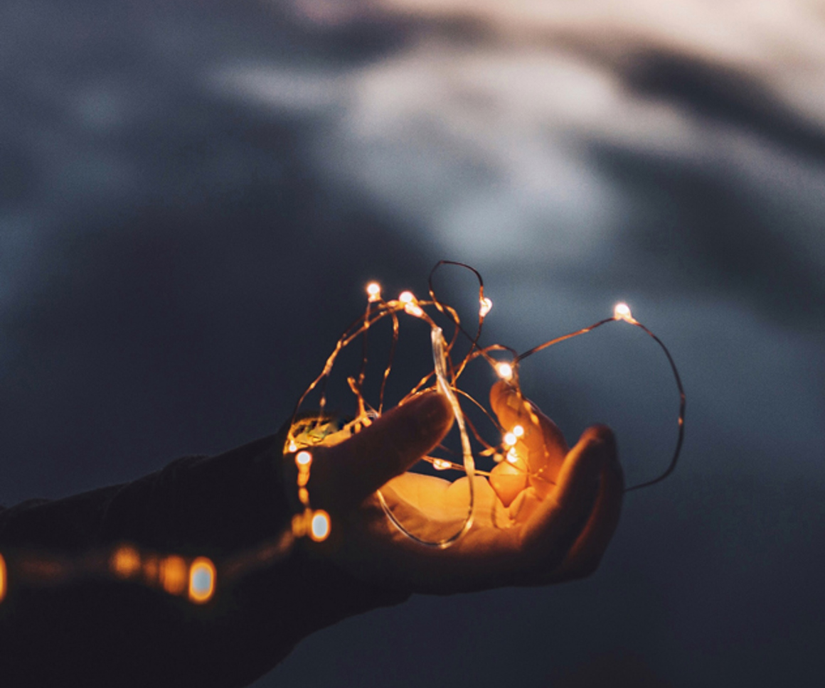 Child's hand holding fairy lights