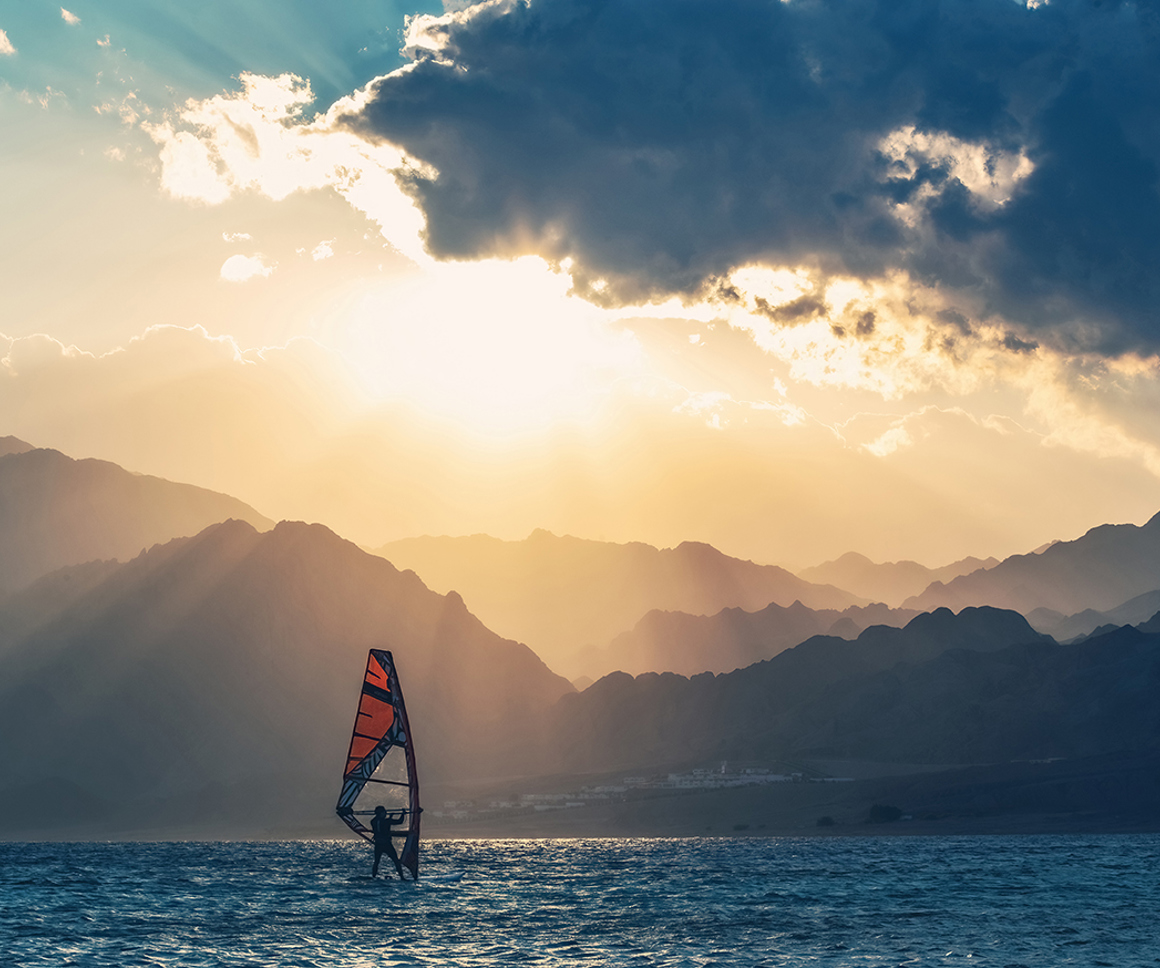 Windsurfing with mountains in the background
