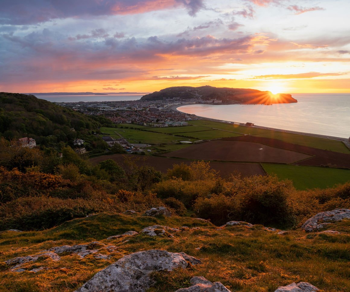 View of seaside town over fields at sunset