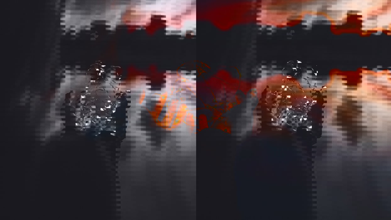 Person Holding Fairy Lights Against An Atmospheric Sky