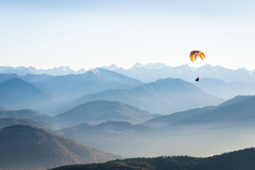Person Gliding Against A Mountain Backdrop
